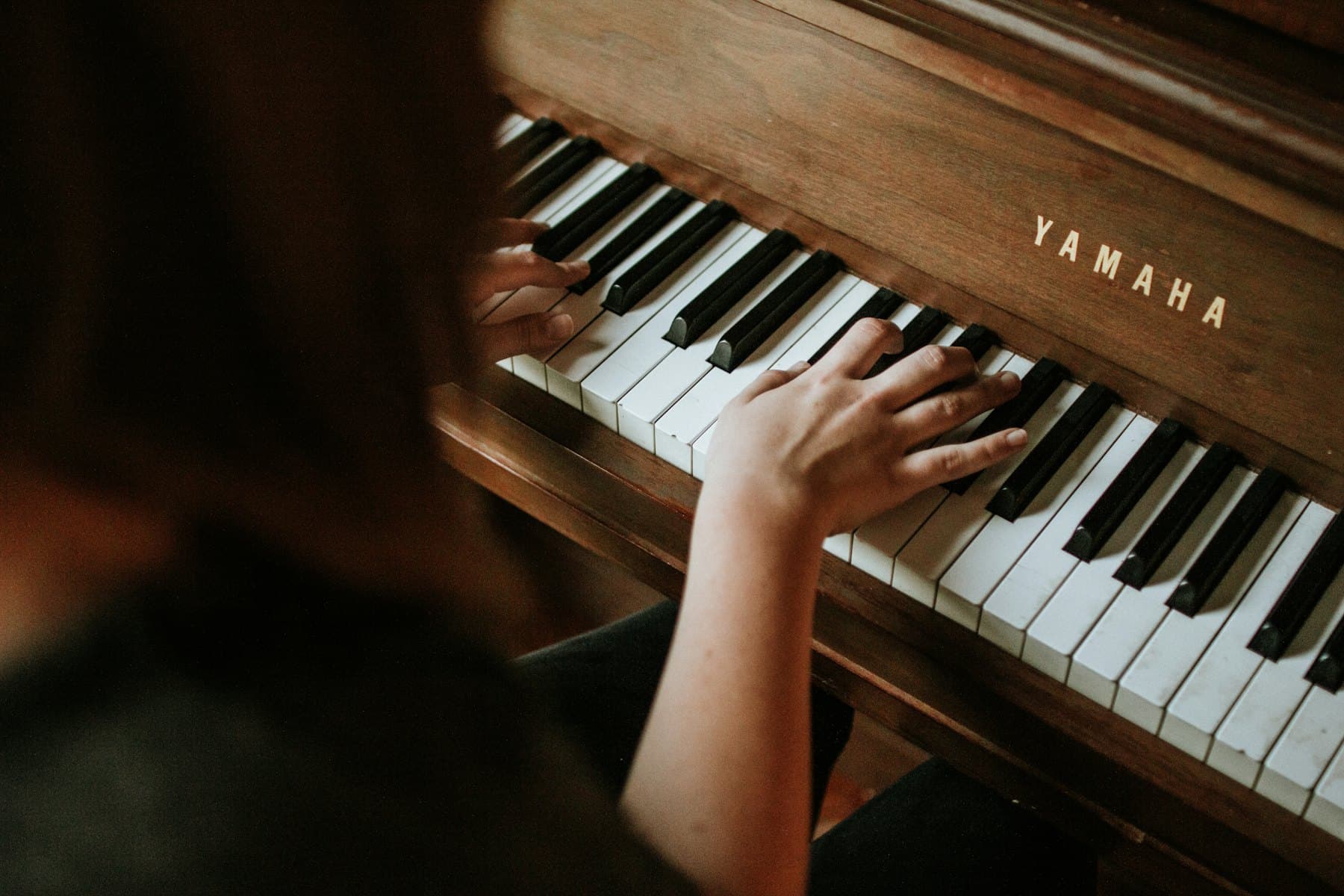 Someone playing an upright piano at home